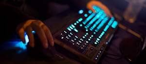 Unas manos sobre un teclado retroiluminado.