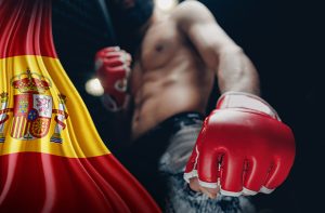 Un luchador de MMA junto a la bandera de España.