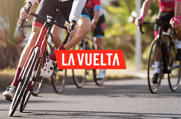 Un grupo de ciclistas junto al logo de la Vuelta a España 2025.